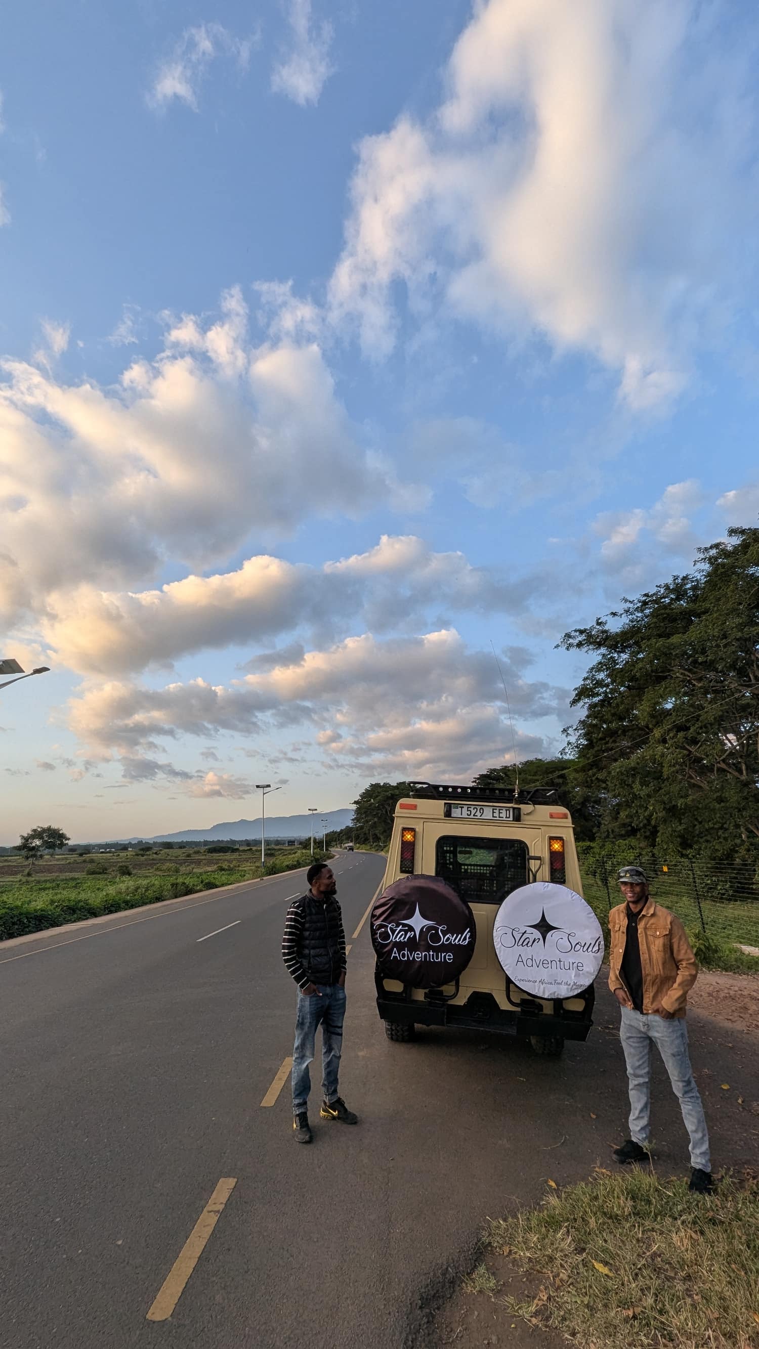 Two Star Souls Adventure guides standing beside their safari vehicle on the road